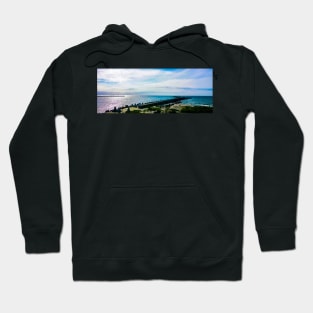 Pier with concrete breakwaters. Seascape, glare on the water of the Baltic Sea, rays of light Hoodie